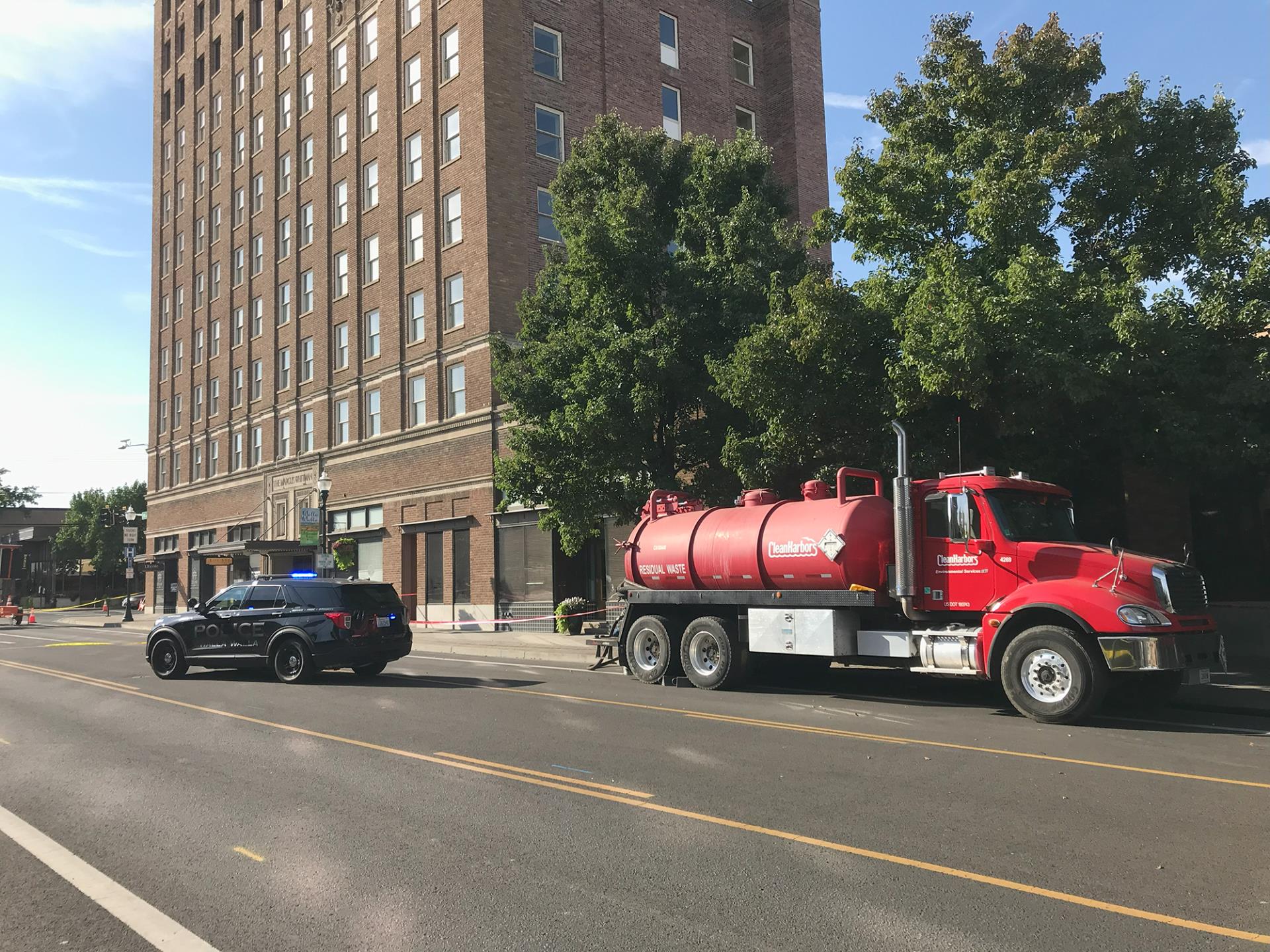 A Walla Walla Police Department vehicle and a frac truck parked on 2nd Avenue next to the Marcus Whitman hotel