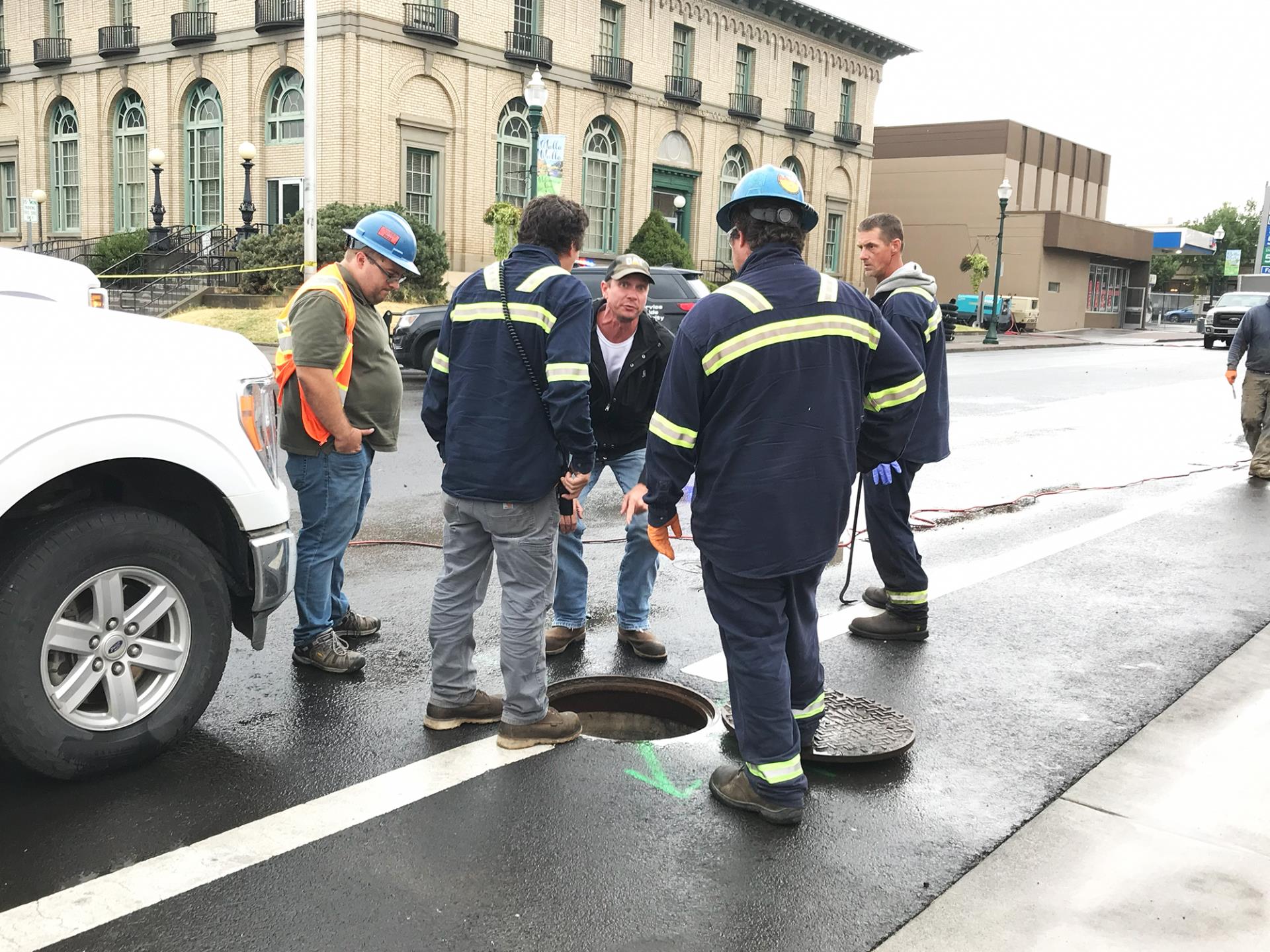 Personnel from Clean Harbors and the Washington State Department of Ecology inspect a stormwater utility access on 2nd Avenue, on Sept. 21, 2023.