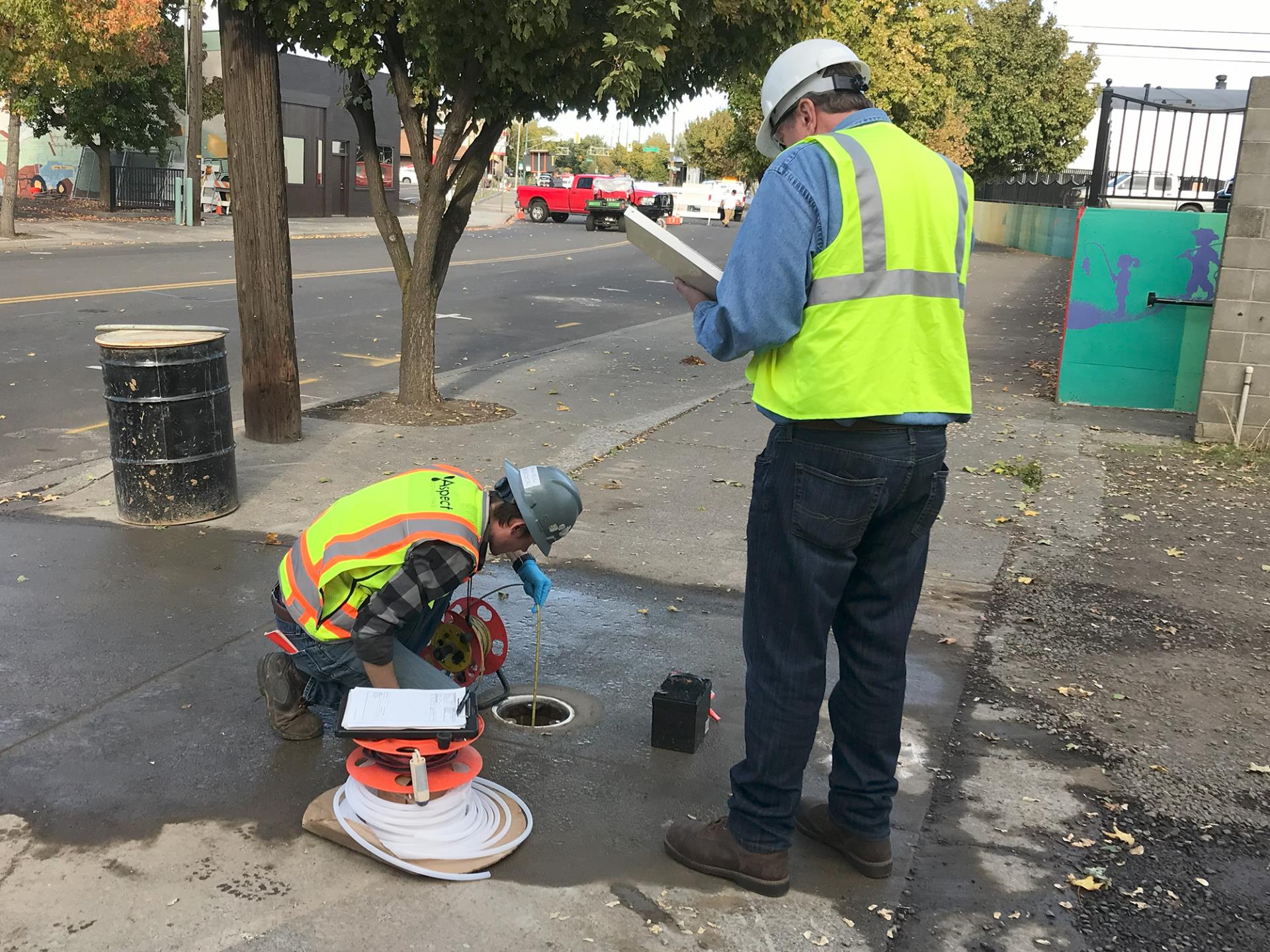 A field geologist with Aspect Consulting measures the depth to groundwater in the monitoring well that was drilled on Oct. 17, 2023.