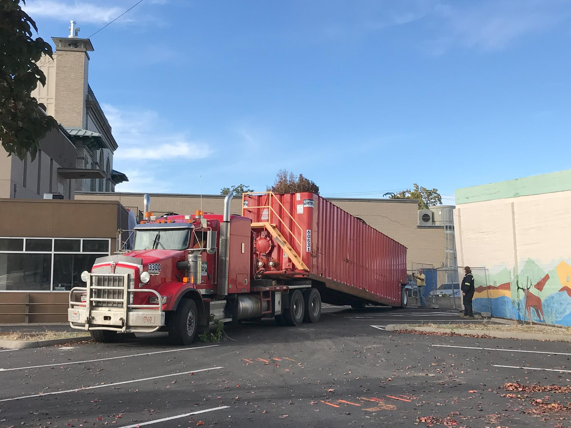 A crew positions a frac tank in the parking lot of 106 N. 2nd Ave., on Oct. 17, 2023.