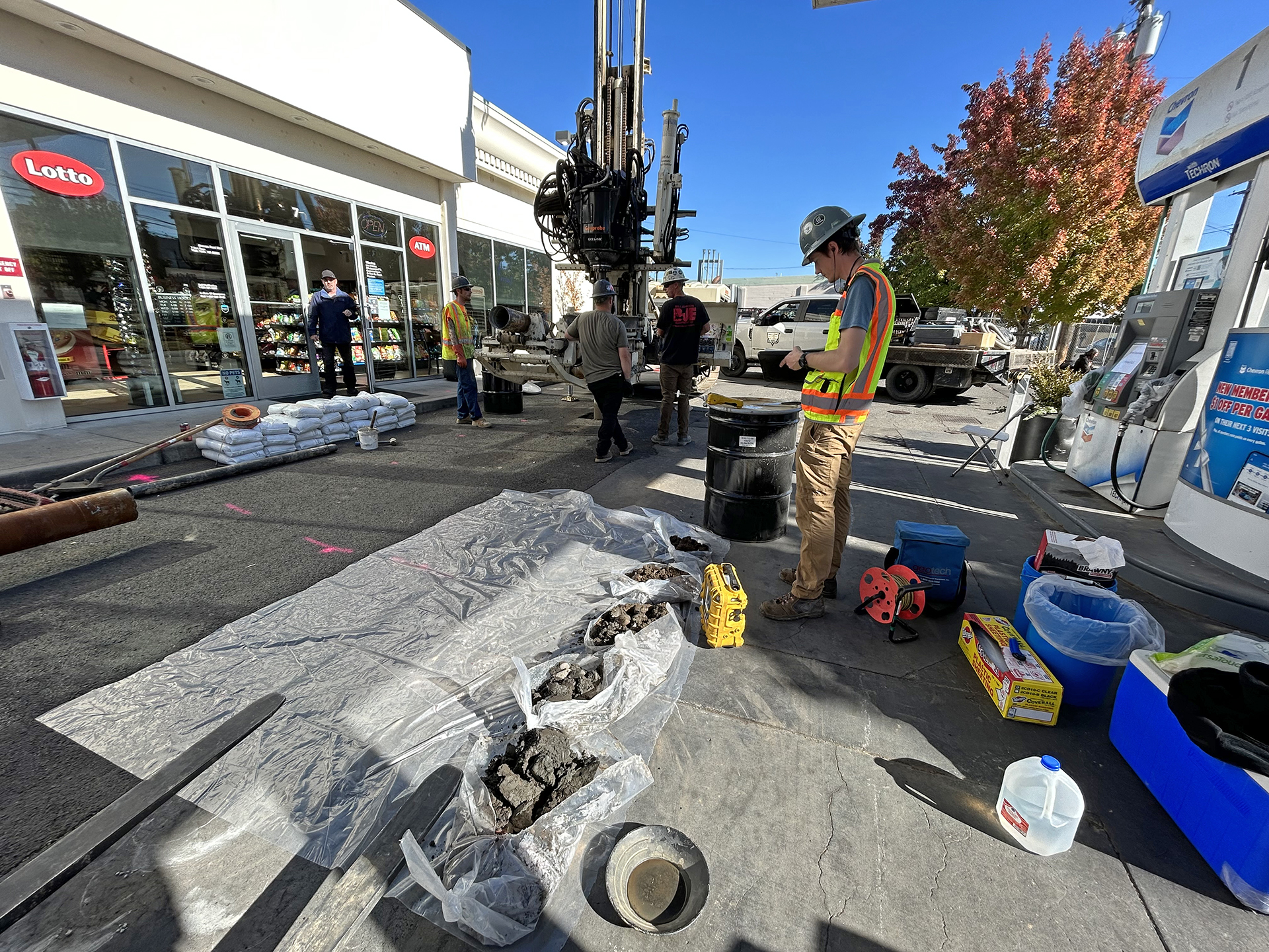 A geologist examines core samples removed during the drilling of a monitoring well on the property of the Chevron station at 2nd and Rose, on Oct. 19, 2023.